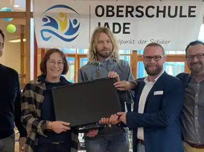 Gruppenbild mit (von links) Carsten Jan&szlig;en (Prokurist der Firma August Br&ouml;tje Handel KG), Anke Duken (IT-Verantwortliche der Firma August Br&ouml;tje Handel KG), Remmer Seewald (Informatiklehrer), Nils Emler (Konrektor), Sebastian Wosnitza (Schulleiter) bei der &Uuml;bergabe der Monitore.