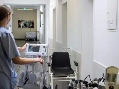 Eine Pflegekraft f&auml;hrt ein Untersuchungsger&auml;t &uuml;ber eine Station. Der hohe Krankenstand beim Personal f&uuml;hrt dazu, dass Operationen verschoben oder abgesagt werden.