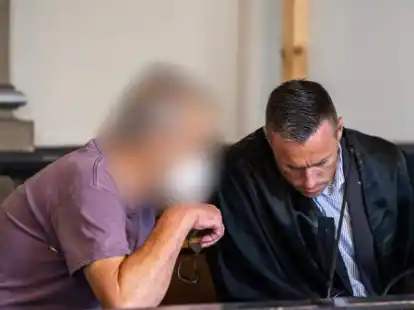 Ein wegen zweifachen Mordes und versuchten Mordes angeklagter Mann sitzt kurz vor Prozessfortsetzung in einem Gerichtssaal des Landgerichts Verden und unterh&auml;lt sich mit seinem Pflichtverteidiger.