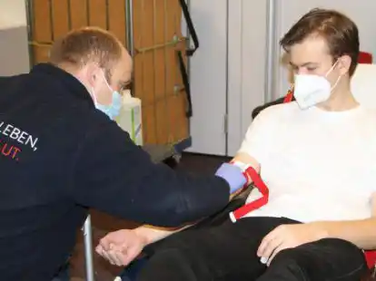 Michell K&ouml;pke von den Maltesern legt einem Sch&uuml;ler am Gymnasium Wildeshausen einen Zugang vor der Blutspende.