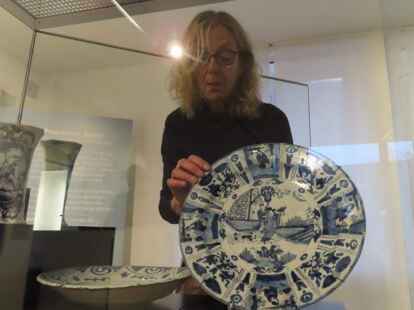 Beim Aufbau: Dr. Annette Kanzenbach mit einem obstschalengro&szlig;en Delfter Fayence-Teller im chinesischen Stil aus dem sp&auml;ten 17. Jahrhundert.