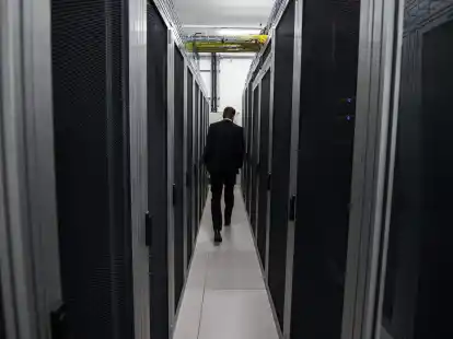 Ein Mitarbeiter der Firma DE-CIX geht zwischen Server-Schr&auml;nken hindurch.