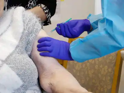 Eine Seniorin erh&auml;lt eine Corona-Impfung.