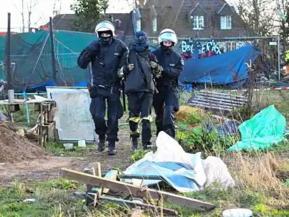 Polizisten f&uuml;hren einen Klimaaktivisten in L&uuml;tzerath vom Gel&auml;nde.