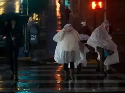 Menschen in Regenponchos &uuml;berqueren eine Stra&szlig;e in San Francisco. Foto: Godofredo A. V&aacute;squez/AP/dpa