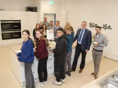 Die neue Schulk&uuml;che der Realschule und der Holbeinschule in Wildeshausen ist seit den Herbstferien in Betrieb. Matthias Ruhle und B&uuml;rgermeister Jens Kuraschinski (von rechts) machten sich am Donnerstag ein Bild vor Ort. Achtkl&auml;ssler der Realschule hatten Flammkuchen zubereitet. Hinten (von links) stehen die Fachlehrer Sebastian T&ouml;njes und Bastian Henken mit Realschulrektor Jan P&ouml;ssel und Grundschulleiterin Inke Bajorat.