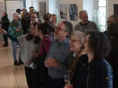 Die Vernissage der Ausstellung: Besucher und K&uuml;nstler betrachten die Werke.