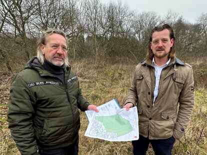 Liegt auf diesem Grundstück eine Bombe? Ralf (links) und Roman Meinardus zeigen eine Karte, die den möglichen Lageort des Blindgängers angibt.