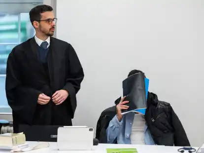 Der Mann, der wegen Vergewaltigung und Freiheitsberaubung an seiner Schwester angeklagt ist, verdeckt vor Beginn des Prozesses sein Gesicht, neben ihm sein Verteidiger (l).