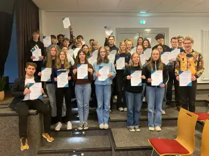 Stolz zeigen sie ihre Urkunden: Die Sch&uuml;lerinnen und Sch&uuml;ler der Peter-Ustinov-Oberschule, die f&uuml;r den Volksbund Deutsche Kriegsf&uuml;rsorge um die H&auml;user gezogen sind und &uuml;ber 2000 Euro gesammelt haben.