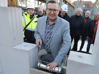 B&uuml;rgermeister Nils Anhuth mauerte Anfang Dezember die H&uuml;lse ein. Aufmerksame Beobachter waren die Mitglieder des Bauausschusses, die Architekten und der Bauleiter.