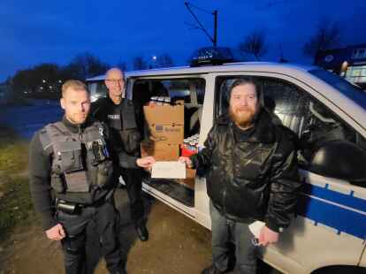Keno Wissel und Wilhelm Kruse vom Bundespolizeirevier Emden &uuml;berreichen die Spende an Adrian Gr&uuml;nefeld, Mitarbeiter der &bdquo;Alten Liebe&ldquo;.