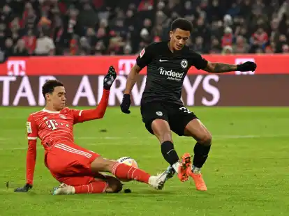 Bayerns Jamal Musiala (l) kommt vor dem Frankfurter Tuta an den Ball.