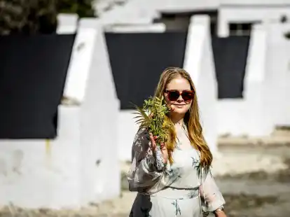 Die niederl&auml;ndische Kronprinzessin Amalia im karibischen Teil des K&ouml;nigreiches Bonaire vor historischen Sklavenh&uuml;tten.