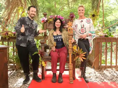 Djamila Rowe sitzt nach dem Sieg beim RTL-Dschungelcamp 2023 mit ihrer Krone auf ihrem Thron. Neben ihr stehen Moderatorin Sonja Zietlow (r) und Moderator Jan K&ouml;ppen.