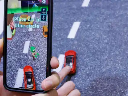 Mittels Smartphone, welches ein reales Spielzeugauto mit der Kamera erfasst, wird beim Spiel &laquo;Zombie Crasher AR&raquo; von Augmented Robotics eine virtuelle Stra&szlig;enszene dargestellt.