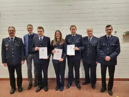 Gemeindebrandmeister Bernd Lembke (links) verpflichtete (vordere Reihe von links) Feuerwehrmann Christoph Neitzel, Feuerwehrfrau Talea Meyerholz und Feuerwehrmann Henrik Lange. Rechts daneben der stellv. Gemeindebrandmeister Norbert Twisterling und Ortsbrandmeister Michel Lampe. In der hinteren Reihe neben Lembke B&uuml;rgermeister Ralf Wessel
