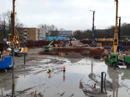 Die drei gro&szlig;en Baumaschinen ragen aus der Baugrube f&uuml;r den Neubau des Klinikums heraus; hinten ist bei den blauen Containern die vierte, kleinere Maschine f&uuml;r Mikropf&auml;hle zu sehen.