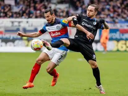 Der Kieler Steven Skrzybski (l) wird von Baris Atik attackiert.