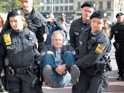 Jesuiten Pater J&ouml;rg Alt wird am 28. Oktober 2022 abtransportiert. Aktivisten der Gruppen Scientists Rebellion, Extinction Rebellion und Letzte Generation blockierten  die Karlsstra&szlig;e in M&uuml;nchen.