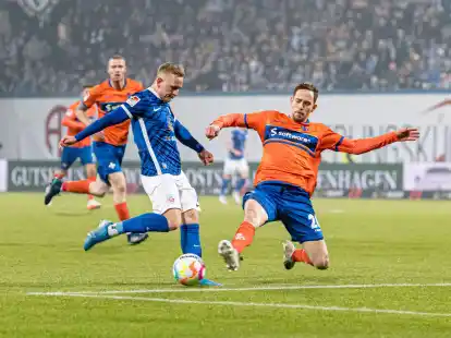 Darmstadts Jannik M&uuml;ller (r) versucht Rostocks Kai Pr&ouml;ger am Torschuss zu hindern.