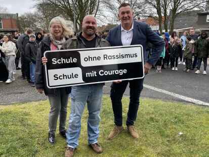 Da ist das Schild: &bdquo;Schule gegen Rassismus &ndash; Schule mit Courage&ldquo;, so darf sich ab sofort die Oberschule Borssum nennen, v.l.: Lehrerin Dorothee Warm, Projektpate und RTL-II-Privatdetektiv Sebastian de Beer (Sebastian van Vrey) und Schulleiter Klaus Runde.