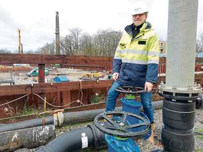 Diplom-Ingenieur Ingo Bennen vor der Gro&szlig;baustelle f&uuml;r den Neubau des Klinikums Wilhelmshaven. Im Vordergrund ist ein Abzweiger der Pipeline zu erkennen. 