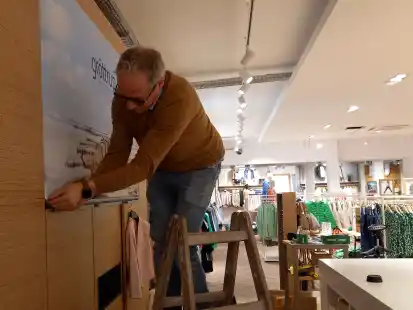 Da wei&szlig; man, wo man ist: Wilko Gr&ouml;ttrup montiert das Firmenlogo im Kassenbereich.