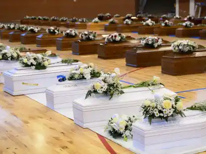 Die S&auml;rge der Opfer des Bootsungl&uuml;cks stehen mit Blumen bedeckt in einer Sporthalle in Crotone.