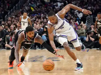 Clippers-Forward Paul George (l) und De'Aaron Fox von den Kings k&auml;mpfen um den Ball.