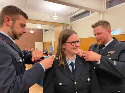 Jannek Arnold (links) und Don Hollje (stellvertretender Ortsbrandmeister) halfen Larissa Semmler beim Befestigen der neuen Schulterklappen.