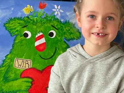 Eine Sch&uuml;lerin freut sich &uuml;ber die gemeinsam gestaltete Bank.