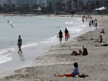 Menschen sonnen sich am Strand von Cala Millor auf Mallorca.
