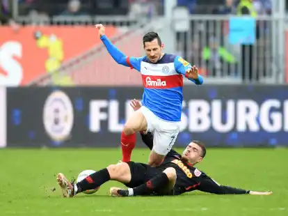 Holstein Kiel um Steven Skrzybski (o.) strauchelt beim Tabellenletzten aus Regensburg mit Blendi Idrizi.