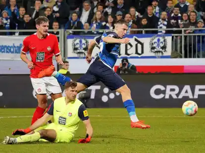 Darmstadts Filip Stojilkovic (r) erzielt den Treffer zum 2:0. Kaiserslauterns Kevin Kraus (l) und Torwart Andreas Luthe (M) schauen hinterher.