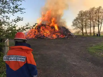 Ein Osterfeuer brennt unter der Aufsicht eines Mitgliedes der Jugendfeuerwehr Bokel-Augustfehn: Auch in diesem Jahr wird die Tradition in der Gemeinde wieder an einigen Orten gelebt.
