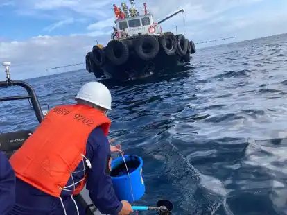 Ein Mitarbeiter der K&uuml;stenwache &uuml;bernimmt  Wasserproben, nachdem ein vor der K&uuml;ste der Philippinen gesunkener Tanker &Ouml;l verloren hat.