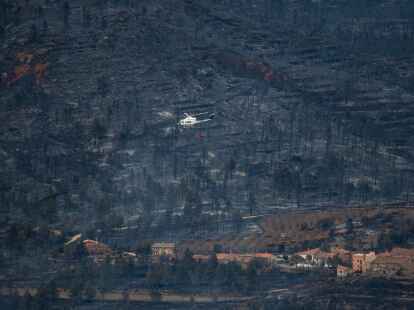 Ein Hubschrauber fliegt in San Agustin &uuml;ber ein verbranntes Gebiet. Vom Wald ist nicht mehr viel &uuml;brig.