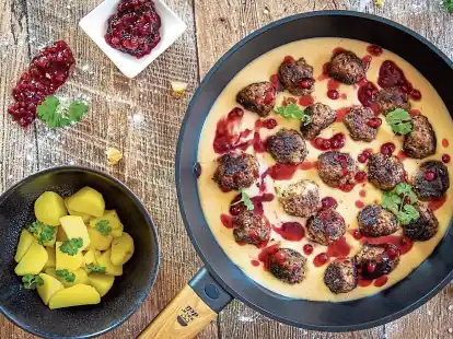 Schwedische Hackfleischb&auml;llchen kommen in einer Rahmsauce auf den Tisch und hei&szlig;en K&ouml;ttbullar. Dazu werden eingekochte Preiselbeeren serviert.