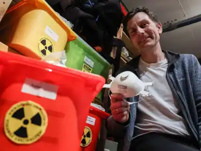 Der Anti-Atomkraft-Aktivist Gereon Hermens sitzt in seinem Keller neben Kisten mit Schutzausr&uuml;stungen.