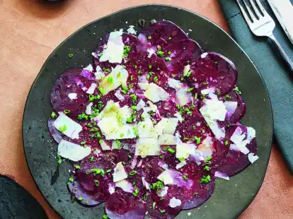 Die hauchd&uuml;nnen Rote-Bete-Scheiben werden mit einem Dressing aus &Ouml;l und Himbeeressig betr&auml;ufelt und mit Parmesan und Schnittlauch dekoriert.