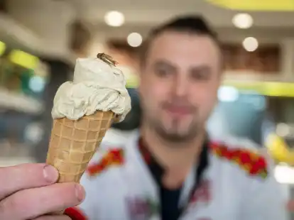 Thomas Micolino, Inhaber des Eiscaf&eacute; Rino, zeigt ein Eis, das zum Teil aus Grillenmehl besteht und auf dem ein getrocknetes Heimchen sitzt.