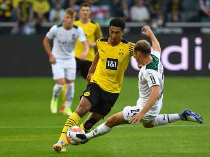 Dortmunds Jude Bellingham im Zweikampf mit Gladbachs Tony Jantschke (r).