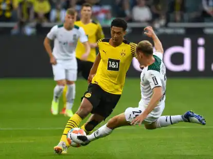 Dortmunds Jude Bellingham im Zweikampf mit Gladbachs Tony Jantschke (r).