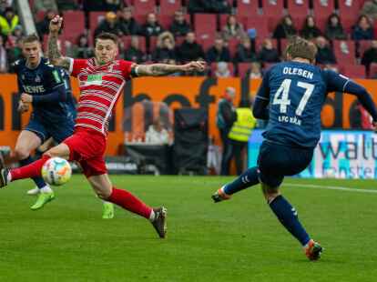 Augsburgs Jeffrey Gouweleeuw (l) stoppt einen Schuss von K&ouml;lns Mathias Olesen.