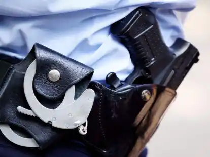 Ein Polizist mit Handschellen und Pistole am G&uuml;rtel (Symbolfoto).