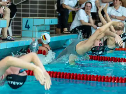 Start zum Rücken-Rennen: zwei Schwimmerinnen des Wardenburger SC mit dem WSC-Logo auf der Schwimmkappe