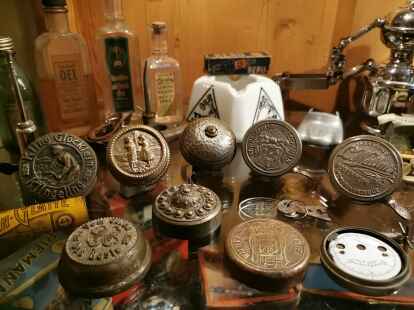 Blick in eine der vielen Museumsvitrinen mit liebevoll arrangierten Ausstellungsst&uuml;cken. Im Mittelpunkt auch hier: H&auml;ndler-Klingeldeckel.