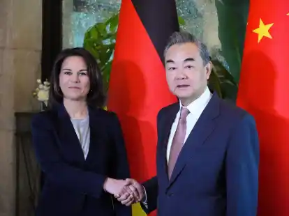 Au&szlig;enministerin Annalena Baerbock gibt Wang Yi die Hand.