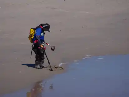 George Pessard mit einem Metalldetektor, Gummistiefeln, einem Sieb und zwei Plastikbeh&auml;ltern am Strand von Coney Island.